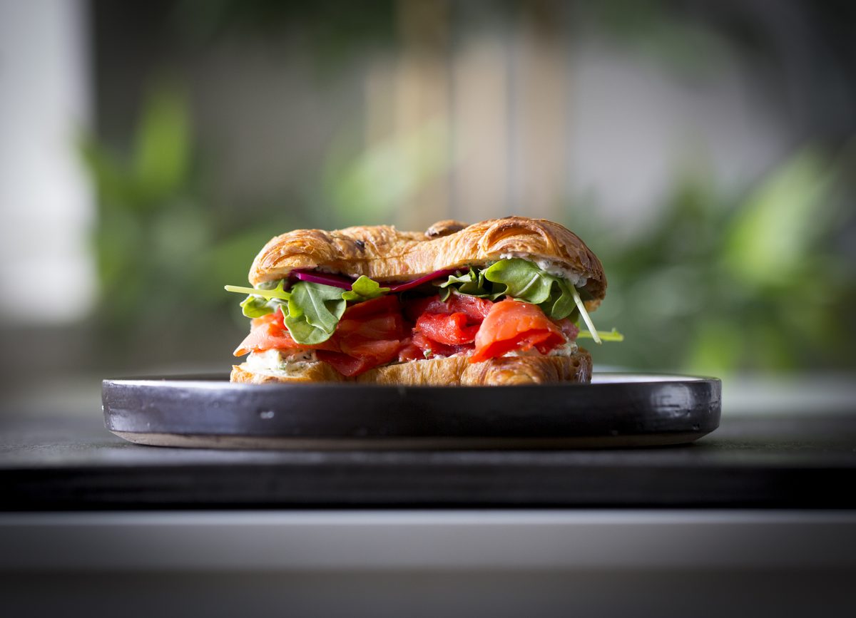 Croissant med lax och ruccola på tallrik